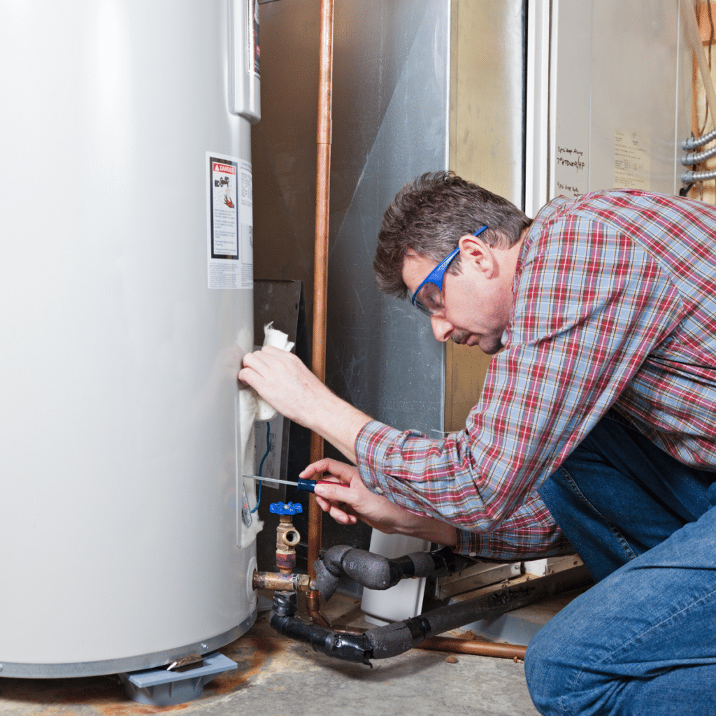 A technician working on a water heater system in a basement
