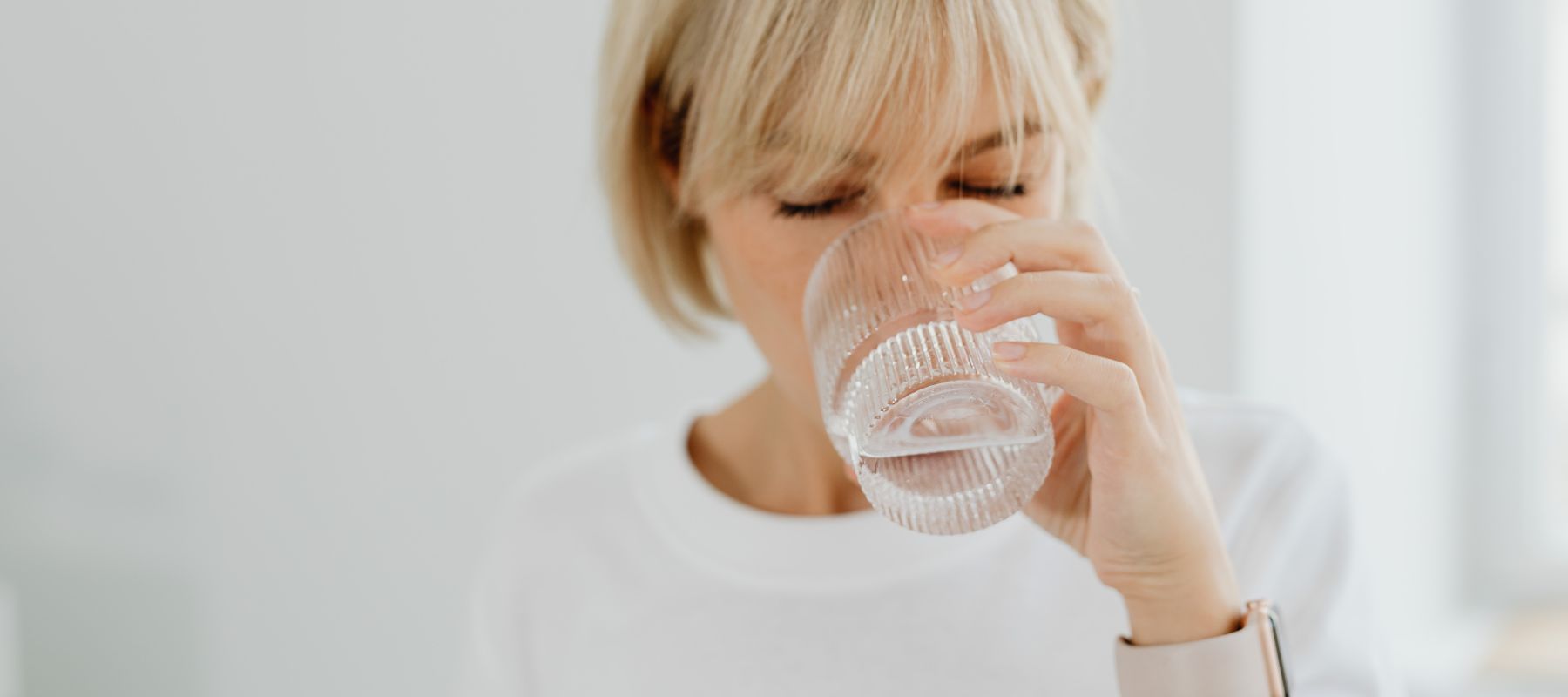 closeup of woman drinking from a glass of water