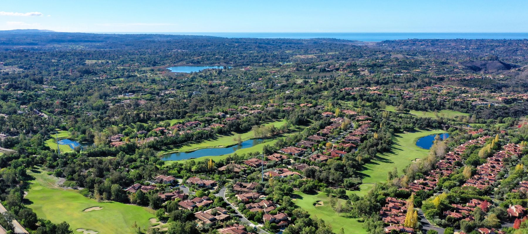 Aerial view of Rancho Santa Fe with golf courses, homes, and surrounding greenery