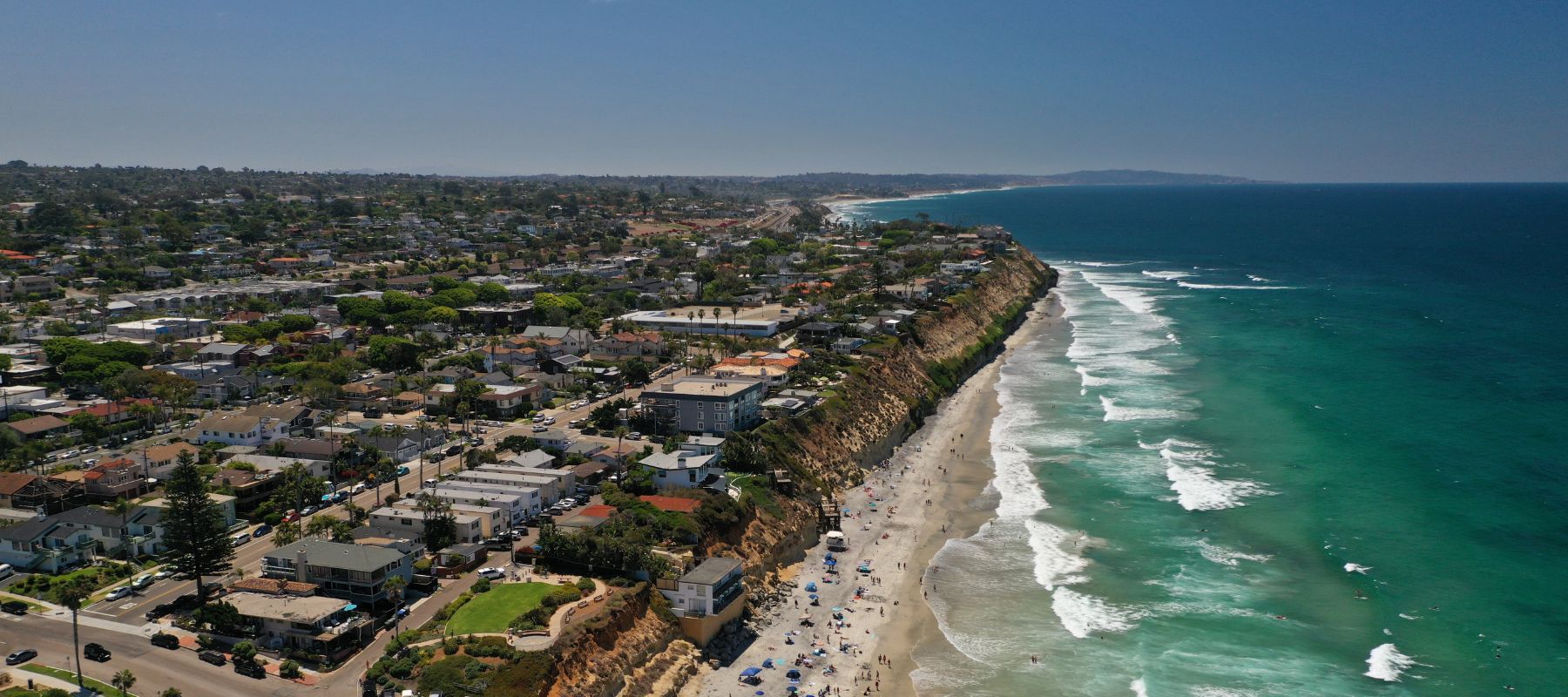 Aerial view of Solana Beach coastline with houses on cliffs overlooking the beach and ocean